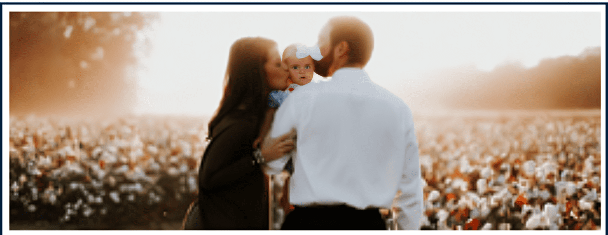 A man and woman kissing while holding a baby.