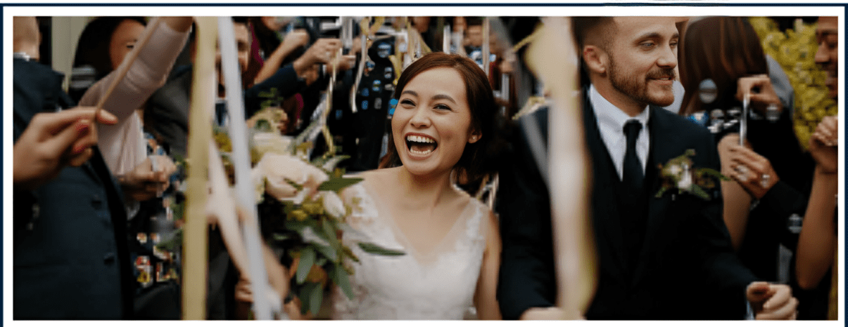 A woman in white dress holding flowers and smiling.