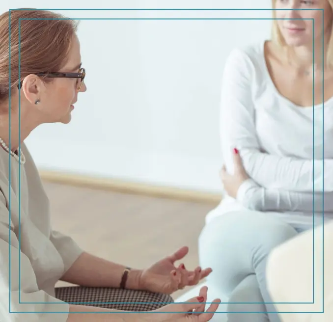 Two women are sitting in a circle talking.