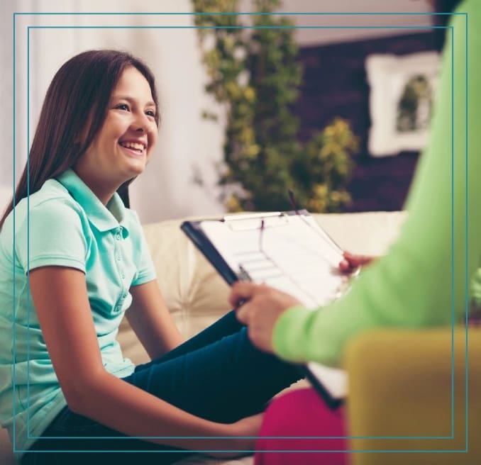 A woman sitting on the couch with another person.