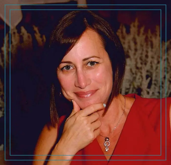 A woman in red shirt smiling for the camera.