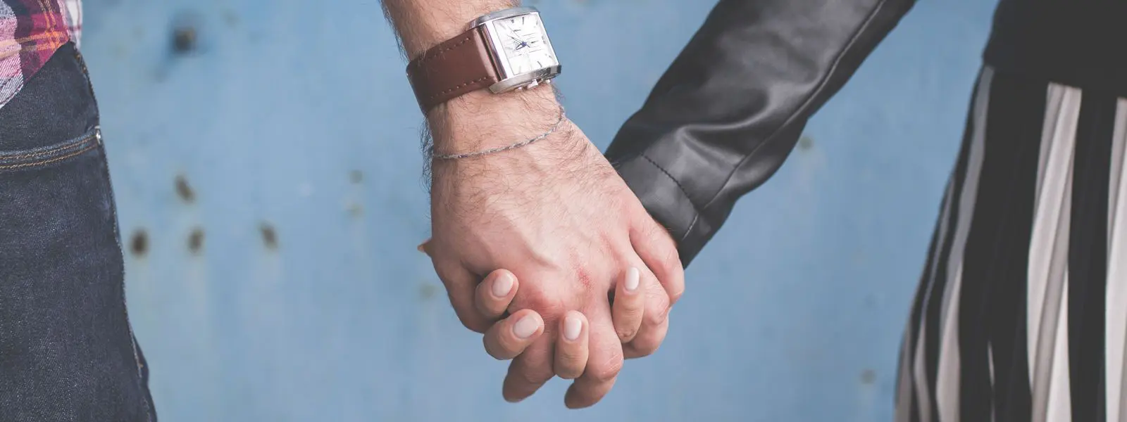 Two people holding hands with a watch on their wrist.