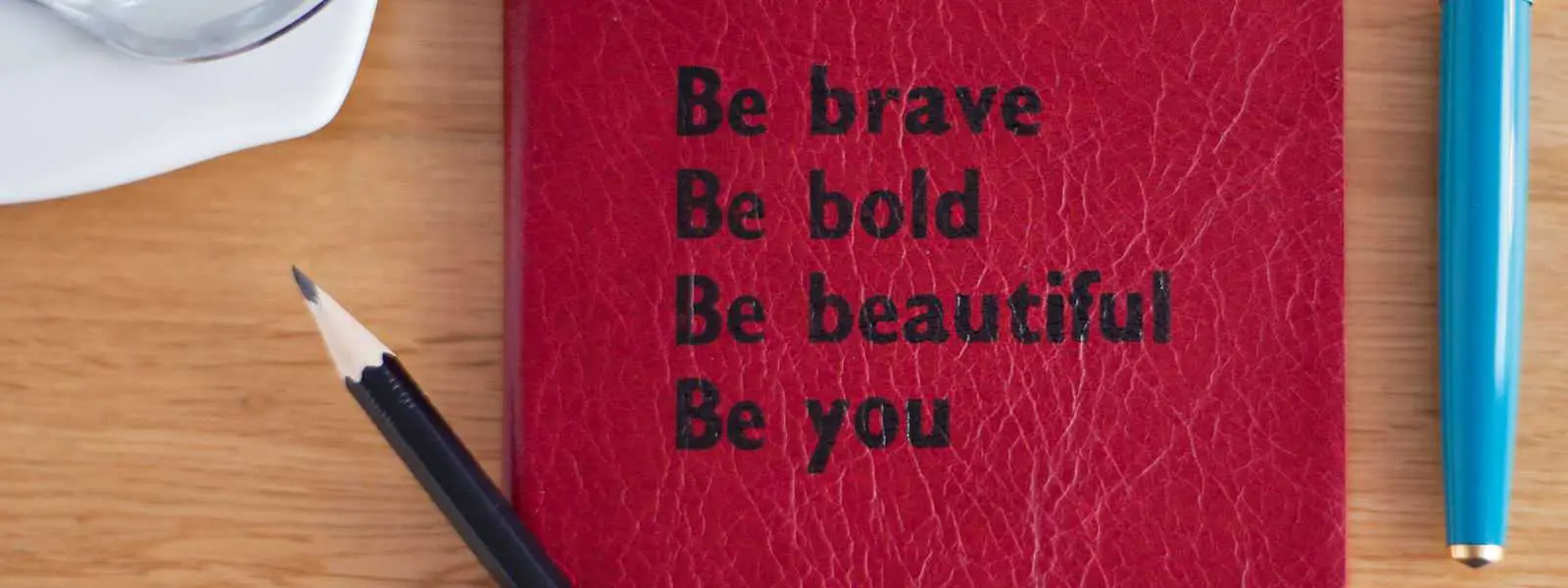 A red book with the words be brave, bold and beautiful written on it.